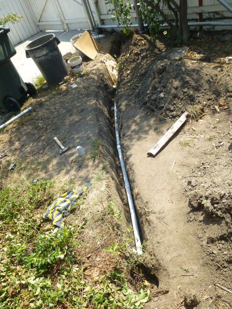 PVC pipe runs down from the pull box and across the yard.